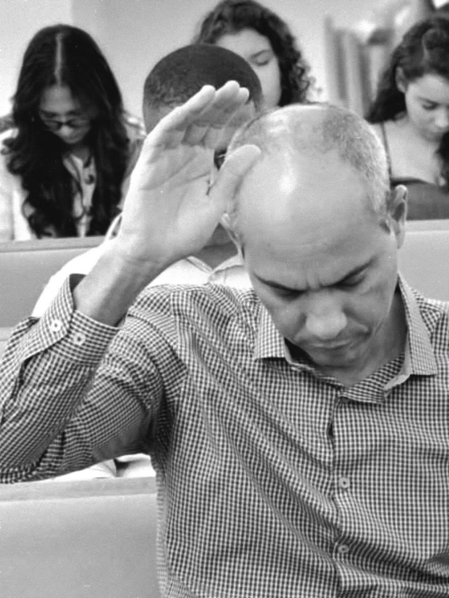 Membro da igreja em oração durante o culto